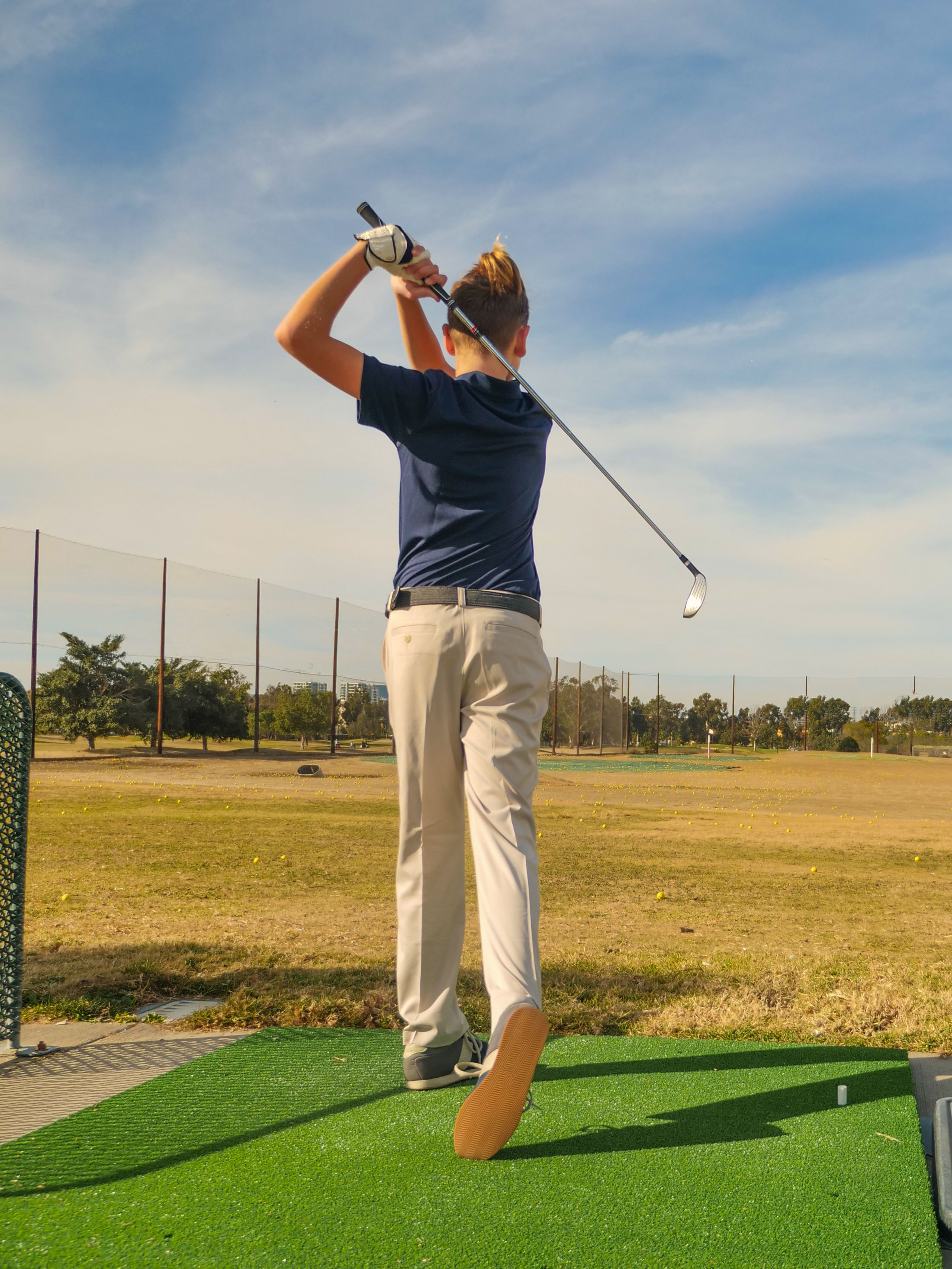 Young golfer practising on a course